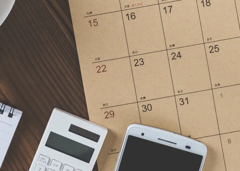 A calculator and a phone on a calendar