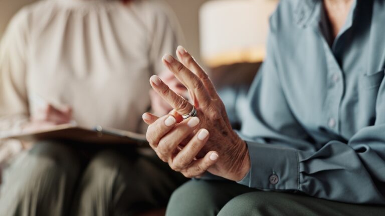 woman touching wedding ring on her hand and talking to lawyer