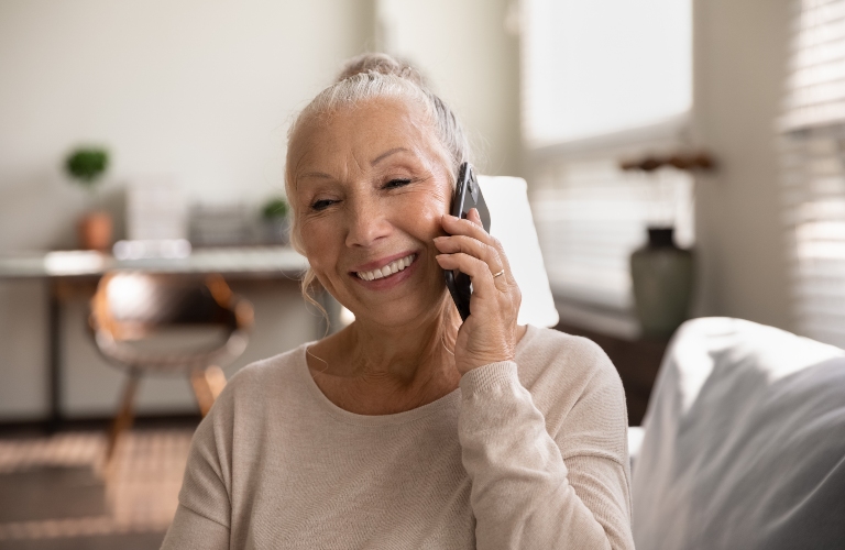 Happy elderly lady talking on cellphone