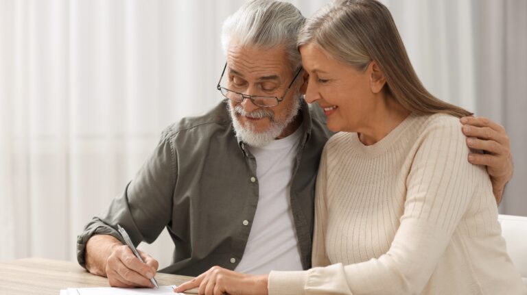 Senior couple signing documents