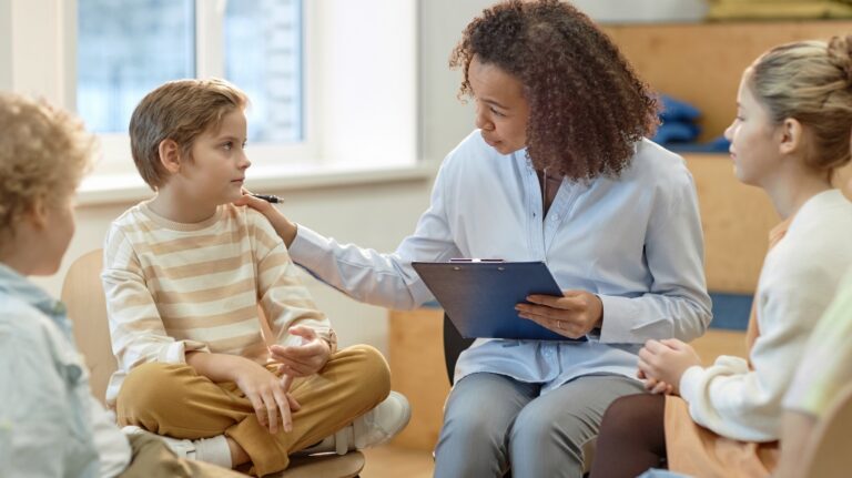 Side view portrait of young female psychologist comforting boy