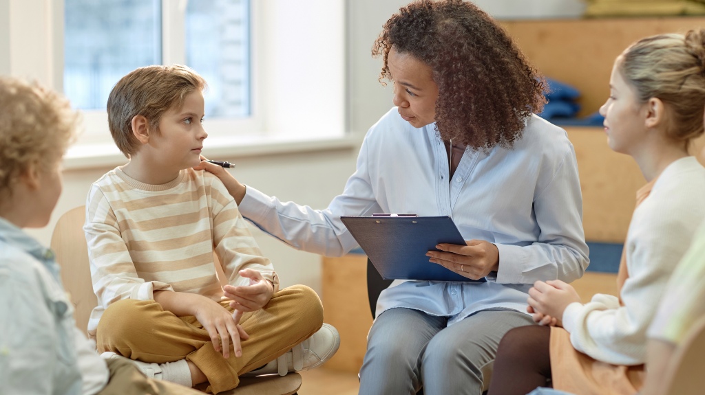 Side view portrait of young female psychologist comforting boy